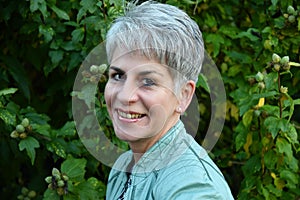 Friendly smiling middle aged woman outside in the garden