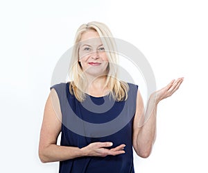 Friendly smiling middle aged woman pointing at copyspace isolated