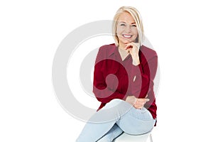 Friendly smiling middle-aged woman sitting on chair isolated on white background
