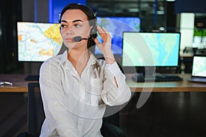 Friendly smiling woman call center operator with headset using computer at office