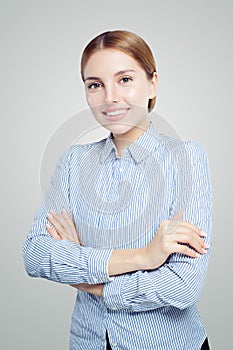 Friendly smiling woman with crossed arms. Student and businesswoman in blue and white striped shirt portrait