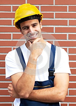 Friendly smiling worker in front of a brick wall photo