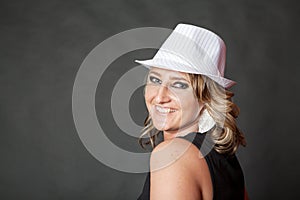 Friendly smiling young adult woman wearing white pinstripe hat