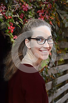 Friendly smiling young woman outside  in autumnal nature