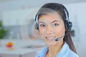 Friendly smiling young woman phone operator at workplace