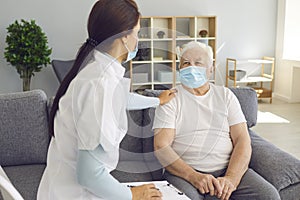 Friendly supportive doctor visiting senior male patient during coronavirus pandemic.