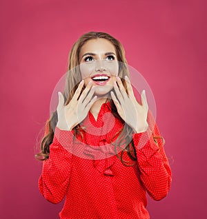 Friendly surprised woman looking up and smiling portrait. Pretty excited model girl on pink background