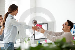 Friendly team congratulating colleague giving present gift, happ