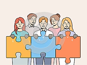 Friendly team people hold puzzle pieces symbolizing working together to solve business problems