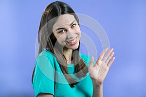 Friendly woman waving hand - goodbye, chao, adios. Parting, say bye to camera. Beautiful girl waving hand on studio