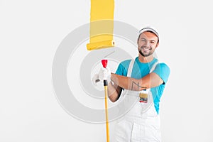 Friendly worker painting wall with yellow paint