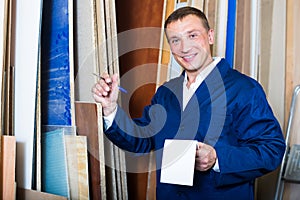 friendly workman standing with plywood pieces