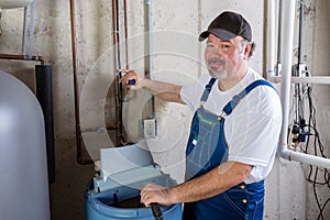 Friendly workman working on a water softener photo