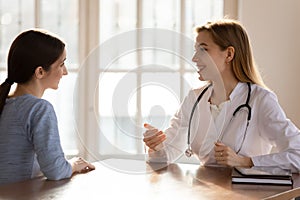 Happy woman enjoying checkup visit with doctor.