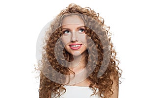 Friendly young healthy lady looking up portrait. Perfect woman with long frizzy hairstyle, natural makeup and fresh skin