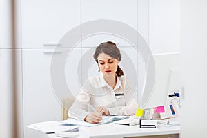 Friendly young woman behind reception desk administrator