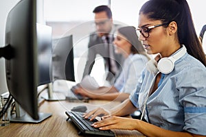 Friendly young woman helpline operator with headphones in call center