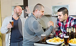 Friends armwrestling at the table