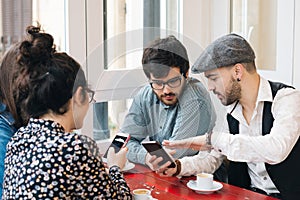 Friends in a bar using mobiles