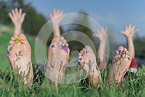 Friends with bare feet lying in field