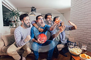 Friends or basketball fans watching basketball game on tv and celebrating victory at home.Friendship, sports and