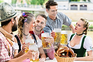 Friends in Bavarian beer garden drinking in summer