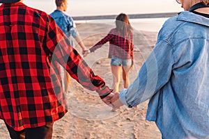 Friends on beach together walking during sunset