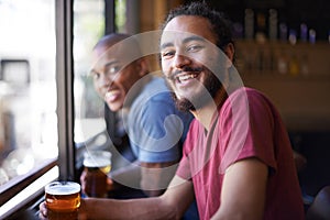 Friends, beer and chill in portrait, smile and relax indoor for fun and bonding in summer to destress. Male people, pub