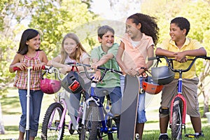 Friends with bicycles scooters and skateboard