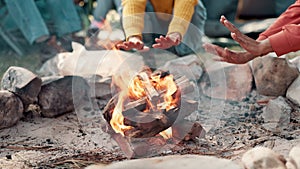 Friends, bonfire and heating hands on camping adventure in forest or burning wood in nature. Flame, smoke and travel in