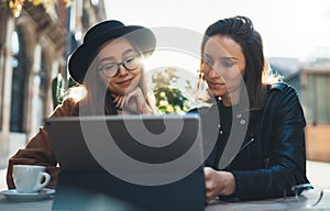 Friends businesswoman communication using digital tablet together. Girls hipster travels in Barcelona sitting in cafe. Business