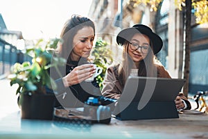 Friends businesswoman using digital tablet. Girls sitting in cafe. Busines communication. Internet laptop technology working photo