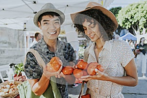Friends buying fresh tomatoes at a farmers market