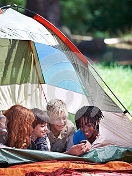 Friends, camping and happy of children in tent for resting, relaxing and bonding with cellphone. Travel gear, smile and