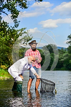 Friends catching fish. Hobby and recreation. Catching fish with soulmate. Bearded man and brutal hipster fishing. Family