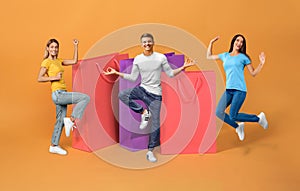 Friends celebrating shopping jumping near large shopper bags, orange background