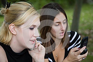 Friends on Cell Phone together (Beautiful Young Blonde and Brunette Girls)