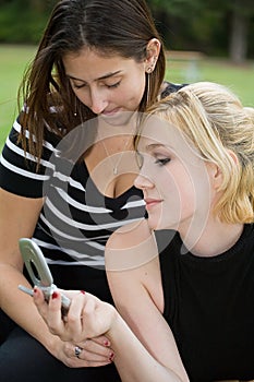 Friends on Cell Phone together (Beautiful Young Blonde and Brunette Girls)