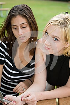 Friends on Cell Phone together (Beautiful Young Blonde and Brunette Girls)