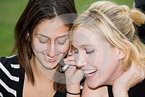 Friends on Cell Phone together (Beautiful Young Blonde and Brunette Girls)