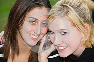 Friends on Cell Phone together (Beautiful Young Blonde and Brunette Girls)