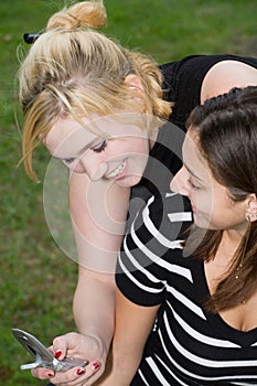 Friends on Cell Phone together (Beautiful Young Blonde and Brunette Girls)