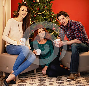 Friends, Christmas and coffee in home, tree with decor in living room for holiday with beverage. Hot chocolate, smile or