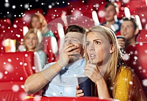 Friends or couple watching horror movie in theater