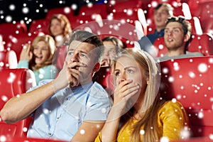 Friends or couple watching horror movie in theater