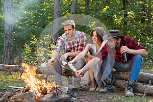 Friends couples enjoy vacation or weekend forest. Weekend hike. Young people enjoying picnic in park on summer day