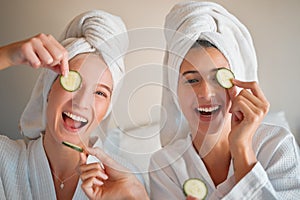 Friends, cucumber and teenager, girl and facial, happy with pampering and beauty in portrait with skincare treatment