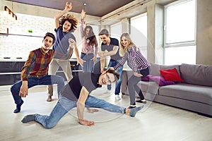 Friends dance at a student`s party in the apartment.