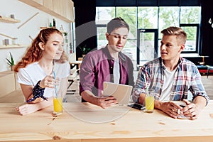 Friends with digital tablet in cafe