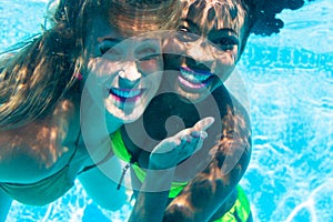 Friends diving underwater in swimming pool